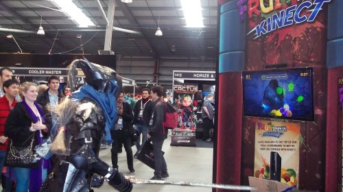 A knight in shining armour playing some Fruit Ninja Kinect at the Halfbrick stall.  With his sword.